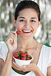 Porträt einer jungen Frau hält eine Schale mit Erdbeeren