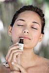 Young woman smelling aromatherapy oil