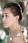 Side profile of a beautiful young woman wearing a shell necklace