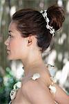 Side profile of a beautiful young woman wearing a shell necklace