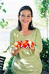 Portrait d'une femme senior holding tomates