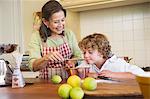 Grandmother and little boy cooking food at kitchen