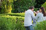 Couple d'âge mûr étreignant leur mère dans un jardin