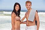 Portrait of a cheerful young couple standing on a beach