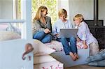 Children and their mother using laptop at house