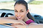 Young woman leaning on car window