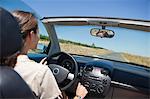 Young woman driving a convertible car