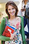 Portrait of a beautiful woman holding books in hand and smiling