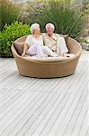 Senior couple sitting in a wicker couch