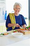 Portrait d'un légume de coupe femme senior dans une cuisine