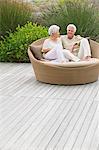 Senior couple sitting in a wicker couch