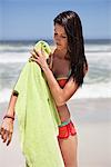 Femme essuyant son corps avec une serviette sur la plage