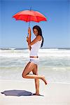 Portrait of a woman holding an umbrella on the beach