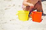 Vue en coupe basse d'une jeune fille jouant avec le sable sur la plage