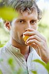 Close-up of a man smelling a lemon