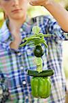 Girl holding a stack of tied up vegetables