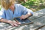 Little boy making drawing of tree on slate outdoors