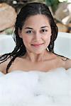 Portrait of a beautiful young woman taking bubble bath