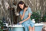 Young woman pouring aromatherapy oil in bathtub