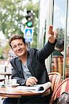 Man signaling for waiter in a restaurant, Paris, Ile-de-France, France