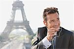 Businessman using a hands-free device with the Eiffel Tower in the background, Paris, Ile-de-France, France