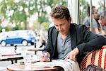 Man reading a magazine in a restaurant, Paris, Ile-de-France, France