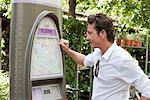 Homme regardant une carte dans une machine de billet, Paris, Ile-de-France, France