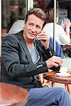 Homme de parler sur un téléphone mobile dans un restaurant, Paris, Ile-de-France, France