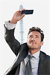 Businessman taking a picture of himself with the Eiffel Tower in the background, Paris, Ile-de-France, France