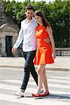 Couple marchant avec bras et souriant, Paris, Ile-de-France, France