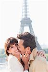 Couple de s'embrasser avec la tour Eiffel en arrière-plan, Paris, Ile-de-France, France