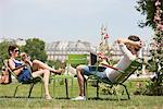 Mann mit einem Laptop mit einer Frau sprechen auf einem Mobiltelefon, Jardin des Tuileries, Paris, France, Frankreich