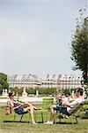 Homme utilisant un ordinateur portable avec une femme assise en face de lui, Jardin des Tuileries, Paris, Ile-de-France, France