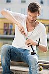 Man opening a wine bottle with a corkscrew, Paris, Ile-de-France, France