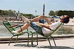 Homme couché sur une chaise et écouter de la musique, Bassin octogonal, Jardin des Tuileries, Paris, Ile-de-France, France