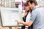 Couple reading menu at a restaurant, Paris, Ile-de-France, France