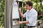 Homme regardant une carte dans une machine de billet, Paris, Ile-de-France, France