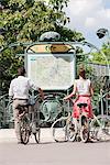 Couple with bicycles looking at a map, Paris, Ile-de-France, France