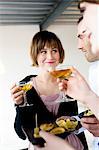 2 women and a man holding glasses of champagne