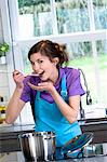 Young smiling woman tasting food