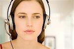 Portrait of a young woman, listening to music with headphones