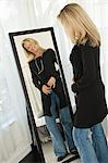 Woman trying on a dress in front of a mirror