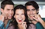 Portrait of three friends eating fruits