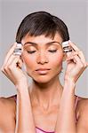 Woman rubbing ice cubes on her temples