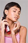 Woman spraying perfume on her neck