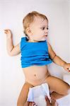 Close-up of a person's hands changing diaper of a baby boy