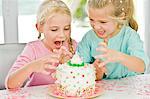 Two girls looking at a birthday cake