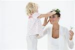 Girl putting a wreath on her mother's head