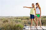 Two girls standing on a boardwalk