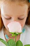 Close-up of a flower girl smelling a flower